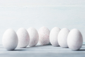 White painted Easter eggs over wooden background.