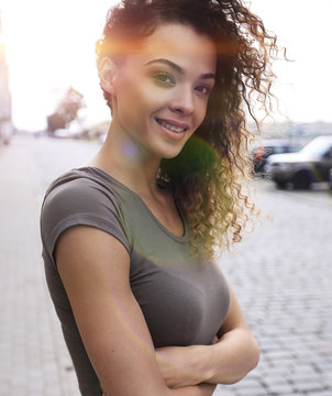 Young woman with afro hairstyle smiling in urban background
