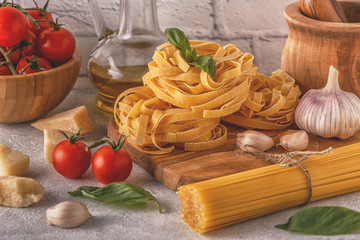 Products for cooking - pasta, tomatoes, garlic, olive oil, basil.