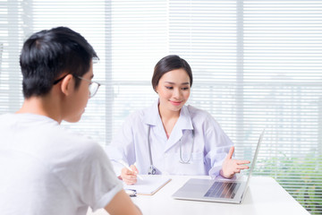 Obraz premium Friendly female doctor hands holding patient hand sitting at the desk