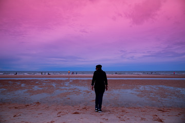 Naklejka premium Lonely girl stands on the beach by the sea.