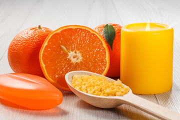 Cut orange with two whole oranges, soap, wooden spoon with sea salt and burning candle