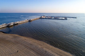 Sopot resort in Poland. Wooden pier (molo) with marina, yachts, ship, beach and walking people. Aerial view at sunrise.