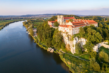 Fototapeta na wymiar Benedictine monastery on the rocky cliff in Tyniec near Krakow, Poland, and Vistula River. Aerial view at sunset