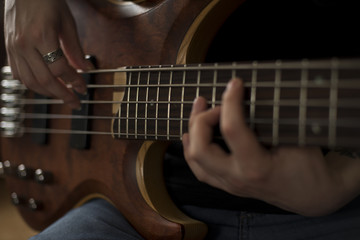Fototapeta na wymiar Hands of rock musician playing the electric bass guitar