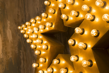 Large wooden star with a large number of lights are lit. Beautiful decor, design. Loft style...