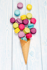 Sweet and colorful French macaroons crumbled from waffle cone