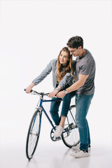 Obraz premium boyfriend teaching girlfriend ride bicycle on white