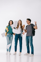 Obraz premium happy multicultural students looking at falling paper on white