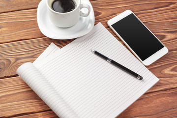 Office desk table top view. Notepad with blank pages on wooden table