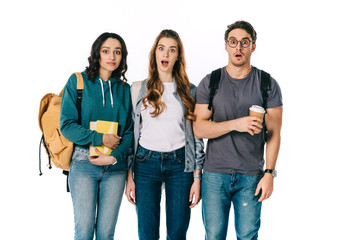 shocked multicultural students looking at camera isolated on white