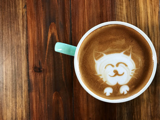 Cute cat face latte art coffee in white cup on wooden table ; love coffee, Cute Neko latte art coffee