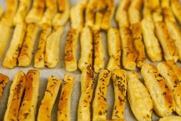 Closeup of a tray with freshly baked cheese crackers with caraway seeds