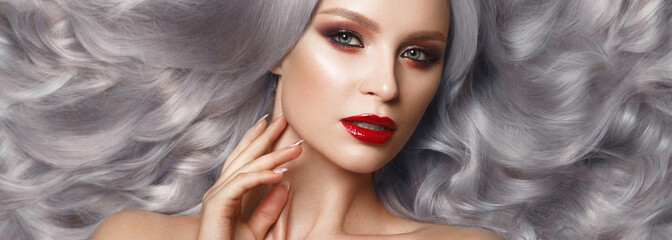 Beautiful woman in a Hollywood manner with color curls, natural makeup and red lips.. Beauty face...
