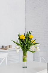 beautiful tulip flowers in vase on table at modern kitchen