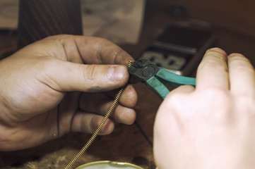 Fototapeta premium jeweler produces gold jewelry in the workshop