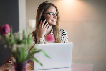 Business woman with laptop and phone in cafe