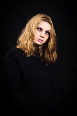 Naklejka premium Portrait of a girl on a black background with bright makeup