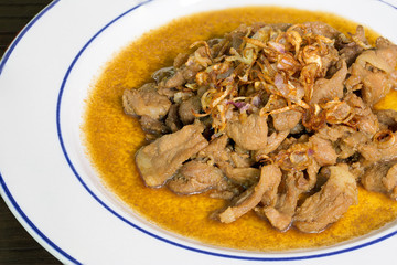 Stir pork slice with coconut sugar sprinkle with fried shallot slice (Sweet pork) in white dish Thai food.