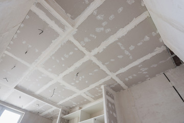 The ceiling is covered with plasterboard sheets during the repair process