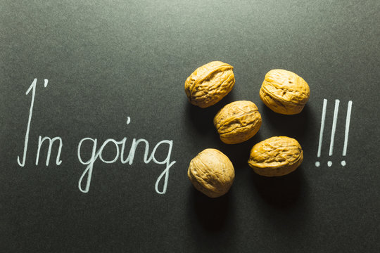 Concept of the phrase I'm going nuts with brown nuts and white hand writing on black paper background