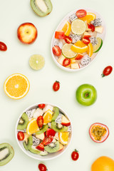 Bowl of healthy fresh fruit salad on white background. Top view.