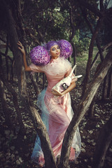 Beautiful model wearing pink dress is posing in a creative wig 