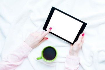 girl uses tablet pc, women's hands, lying on the blanket, white background with copy space, for advertising, top view