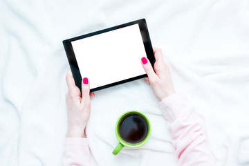 woman uses tablet pc, women's hands, lying on the blanket, red manicure, white background with copy space, for advertising, top view