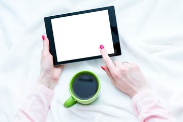 woman uses tablet pc, women's hands, lying on the blanket, red manicure, white background with copy space, for advertising, top view