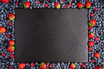 Summer berries background. Frame with berries assorted mix of strawberry, blueberry, raspberry. Top view