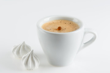 coffee in a porcelain cup, black coffee and white meringues, the dynamics and spike of coffee