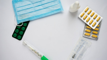 Medication pills, thermometer and hypodermic on white background