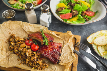 Grilled ribs with buckwheat, salads with citrus and grilled liver, Caesar salad with tomato.