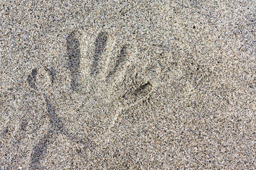 Child hand imprint on the sand