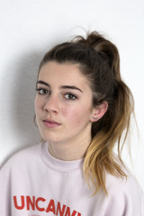 Fototapeta premium Portrait of a young girl with serious face. Vertical shot with natural light