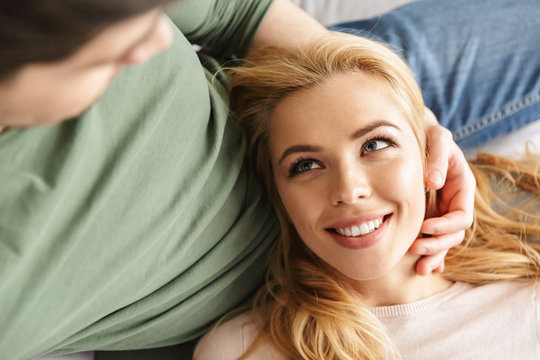 Cute smiling young woman lies on her husband