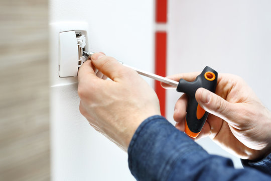 Montaż włącznika światła.  Elektryk montuje włącznik światła w instalacji elektrycznej.