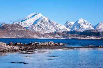 Naklejka premium Scenery winter landscape in the Norway, wild northern nature. Rocky mountains with sea coast and serene blue sky, Lofoten Islands, Napp, Flakstad
