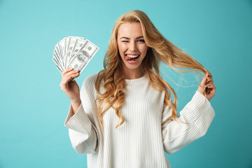 Portrait of a playful young blonde woman in sweater