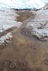 Snow melts on the road as a background
