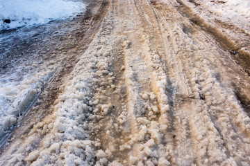 Snow melts on the road as a background