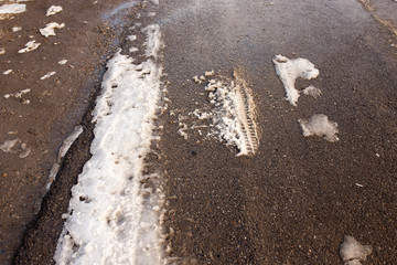 Snow melts on the road as a background