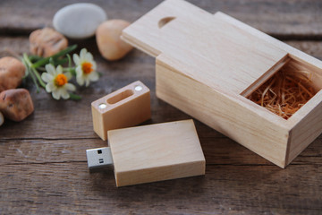 Wood usb flash drive  with wooden box  on rustic wood floor and decorate with flower and stone. ecology concept.