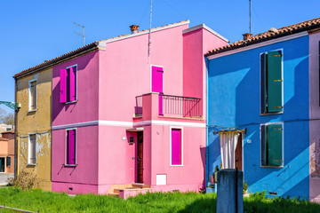 Fototapeta na wymiar Daylight view to vibrant pink and blue houses facades