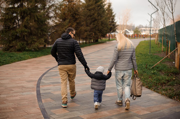 Obraz premium Young family couple walking with a son