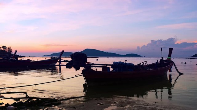 beautiful sunrise, longtail boats at the tropical andaman calm sea