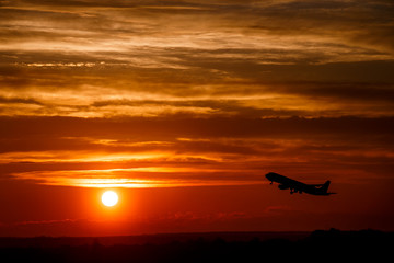 Airplane at sunset sky in the air with space for text. Silhouette of a big passenger  aircraft in sun light. transportation concept. plane flying in the dramatic sky. amazing atmospheric image
