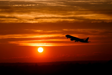 Airplane at sunset sky on sun in the air with space for text. Silhouette of flying aircraft in sunlight. transportation concept. plane taking off in the dramatic sky. amazing atmospheric image