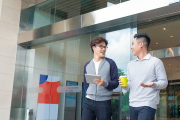 Fototapeta premium Two smiling businessmen walking and talking in the city